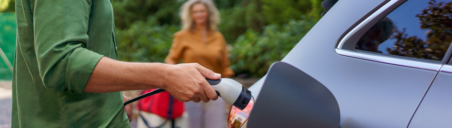 Image of a man plugging in his electric vehicle